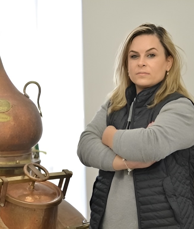 Milica Pletvarska, Smidgin's master distiller, standing beside the copper alembic still